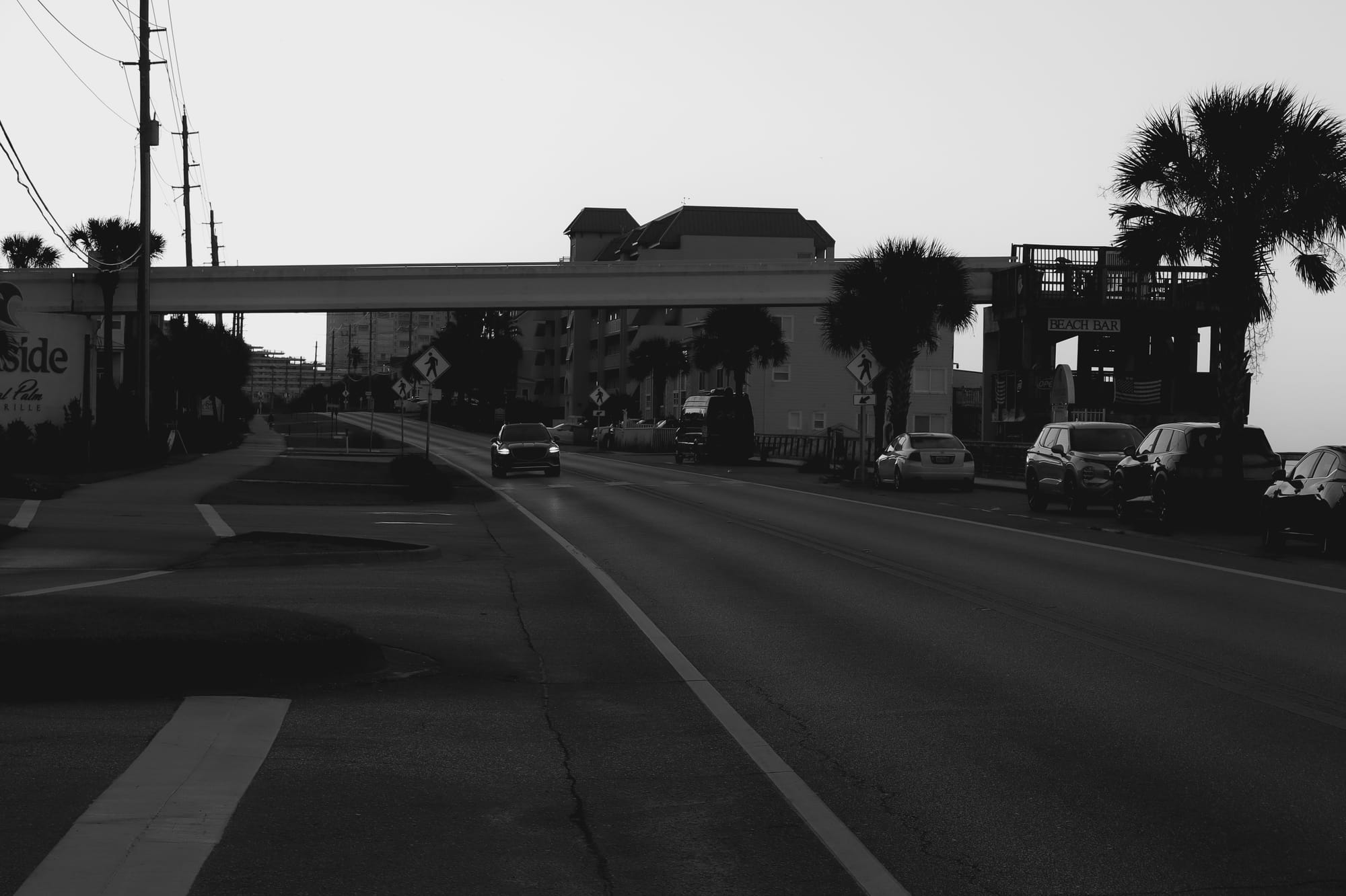 A car drives alone down the boardwalk.