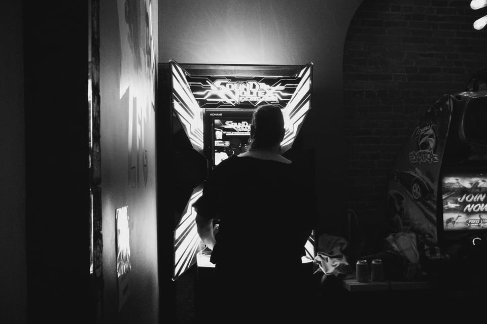 The author plays a brightly-lit arcade machine.
